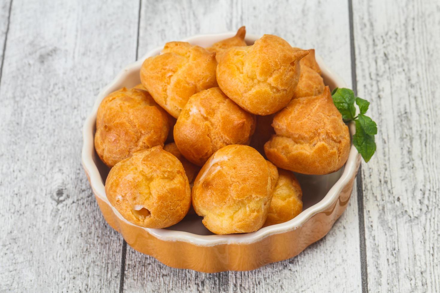 pilha de profiteroles doce e saborosa na tigela foto