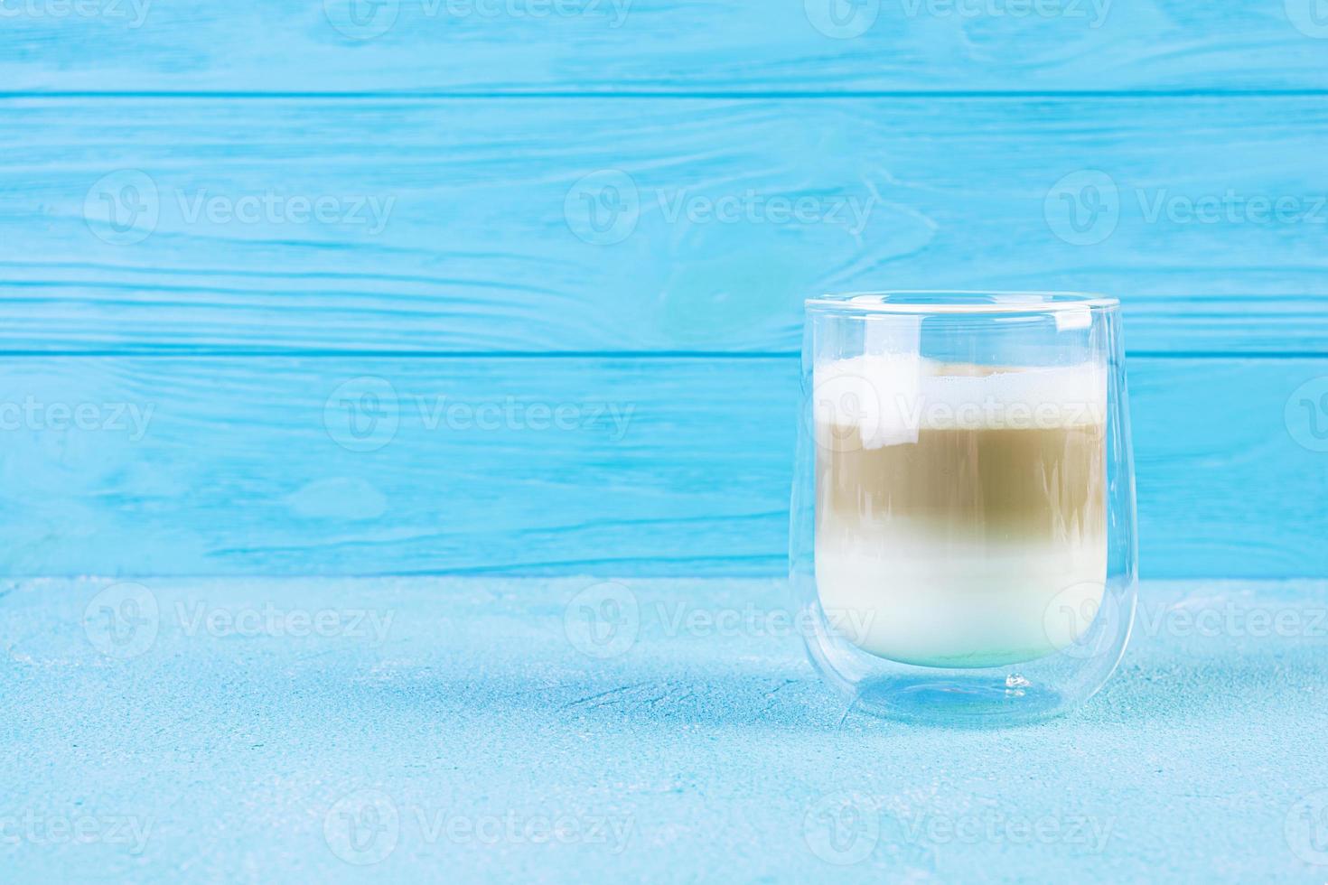 xícara de café macchiato. café de bebida quente em fundo azul foto