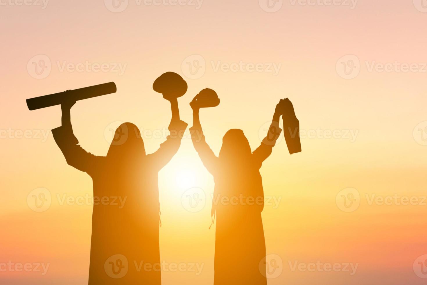 silhueta de engenheiro de negócios do Oriente Médio árabe homem equipe celebração sucesso felicidade ao pôr do sol à noite fundo do céu foto