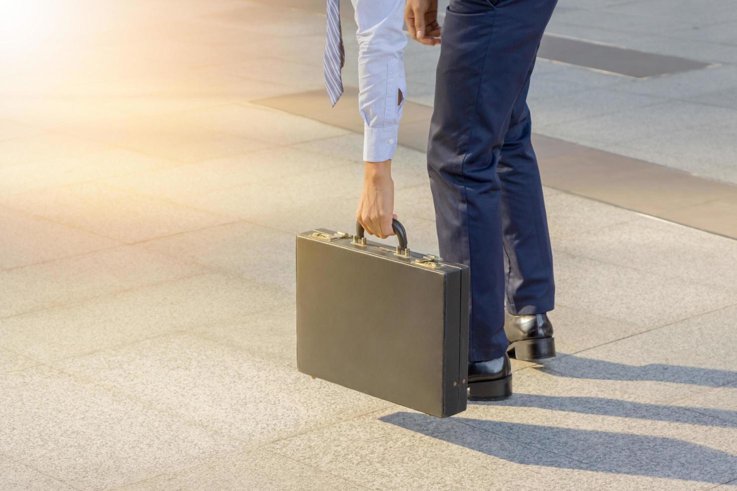 empresário segurando maleta de couro indo trabalhar foto