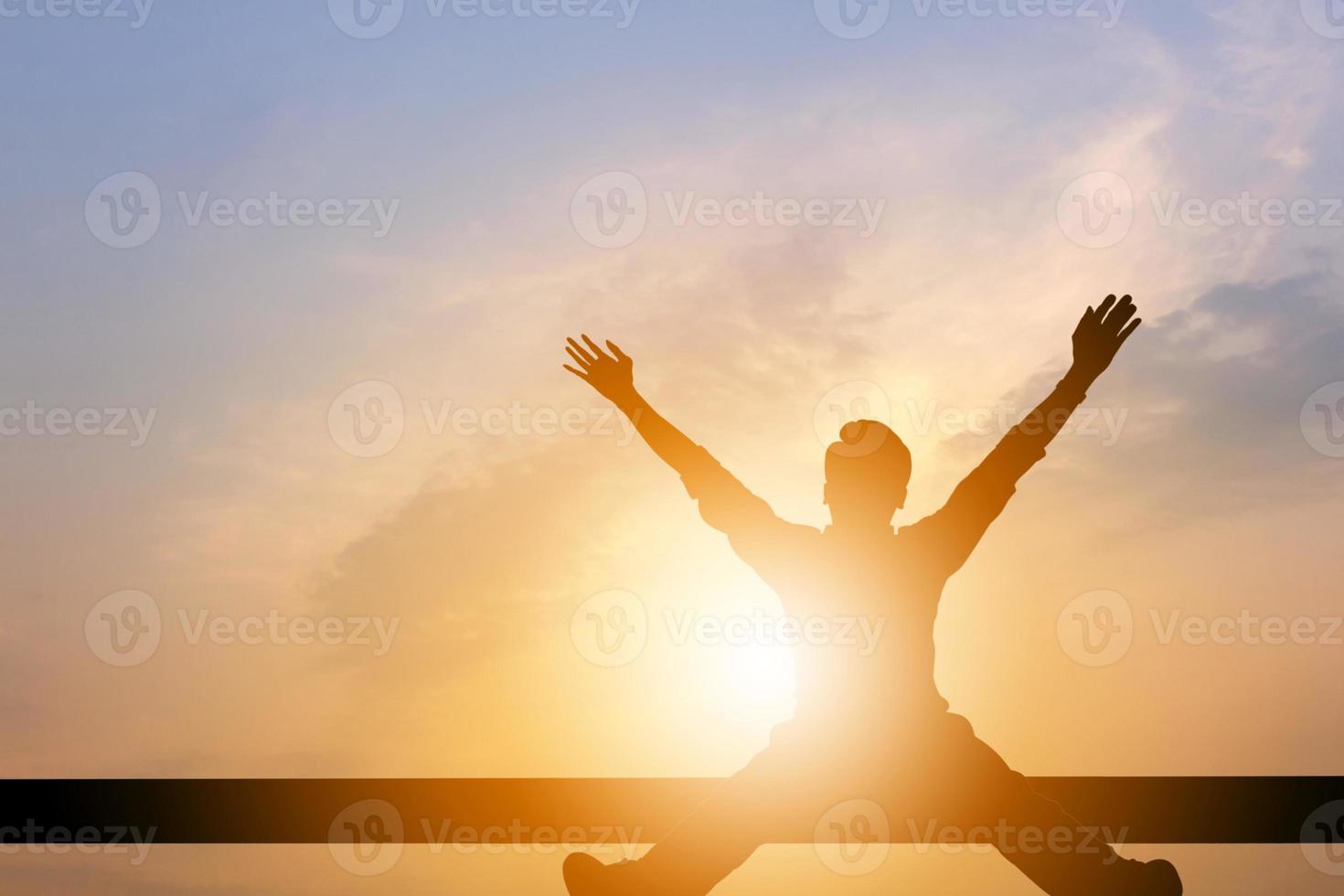 silhueta de felicidade de sucesso de celebração de homem de negócios relaxada em um pôr do sol de céu noturno de madeira, esporte e conceito de vida ativa. foto