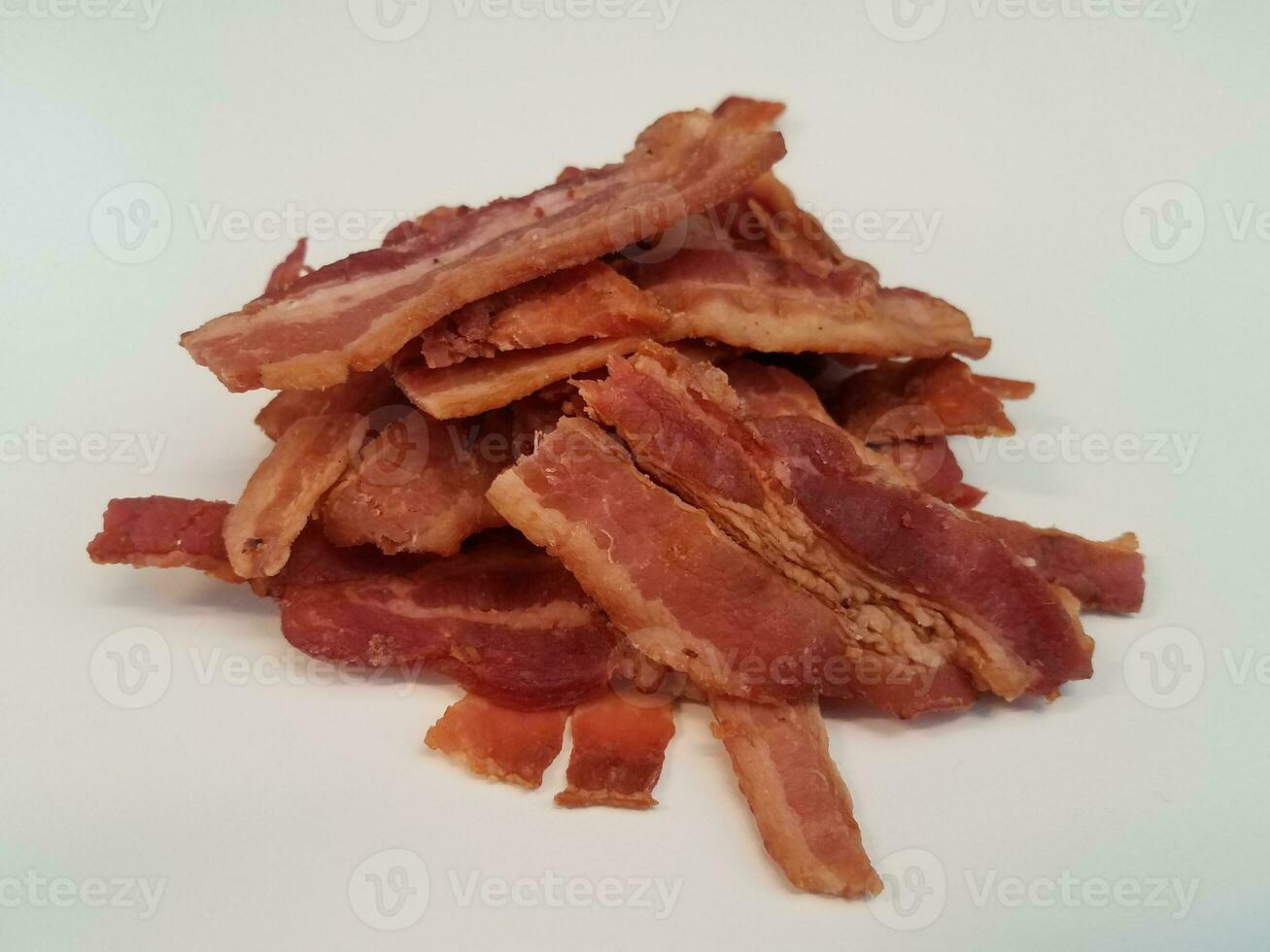 pilha ou monte de tiras de bacon na superfície branca foto
