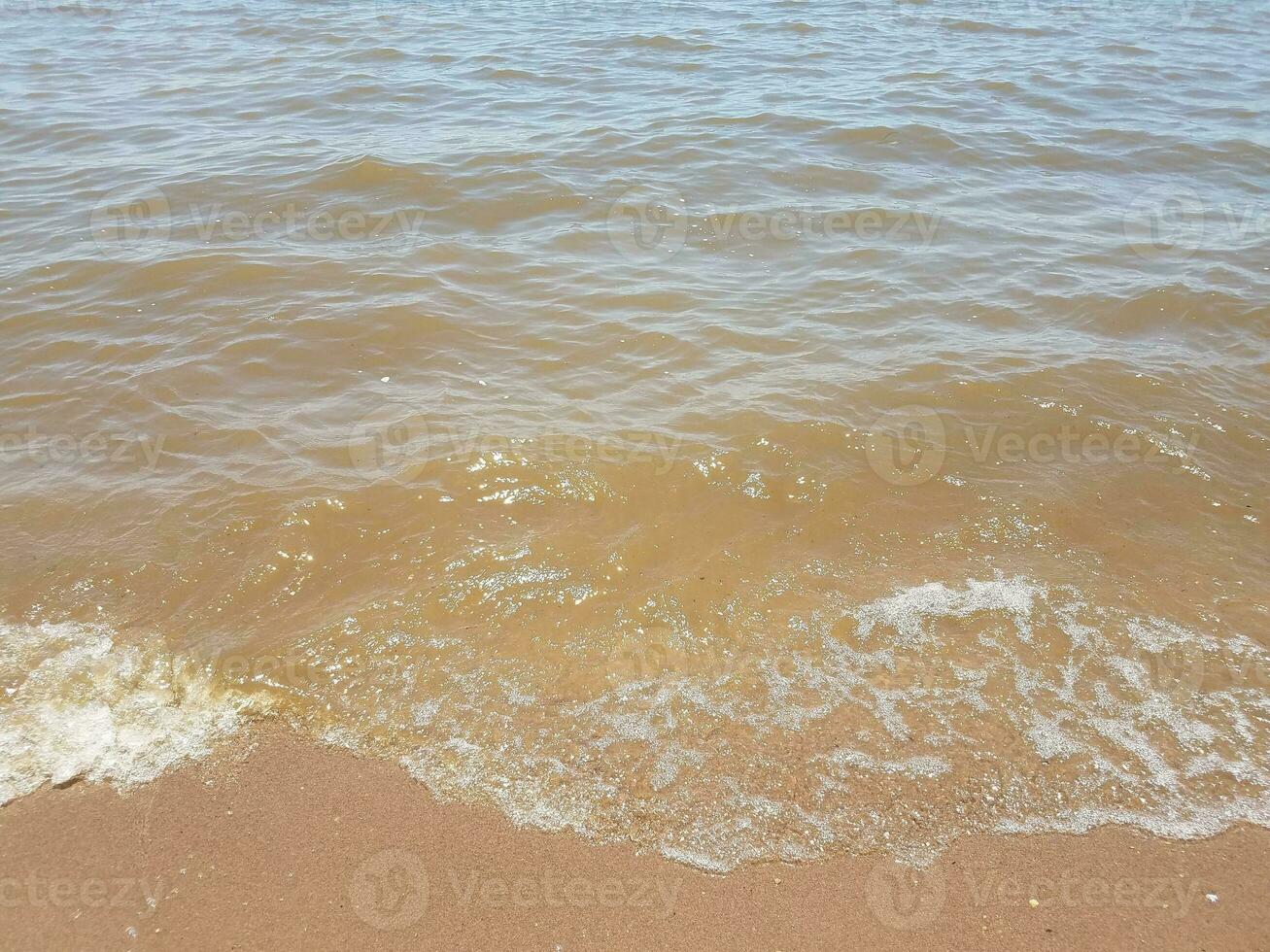 areia com ondas e pedras foto