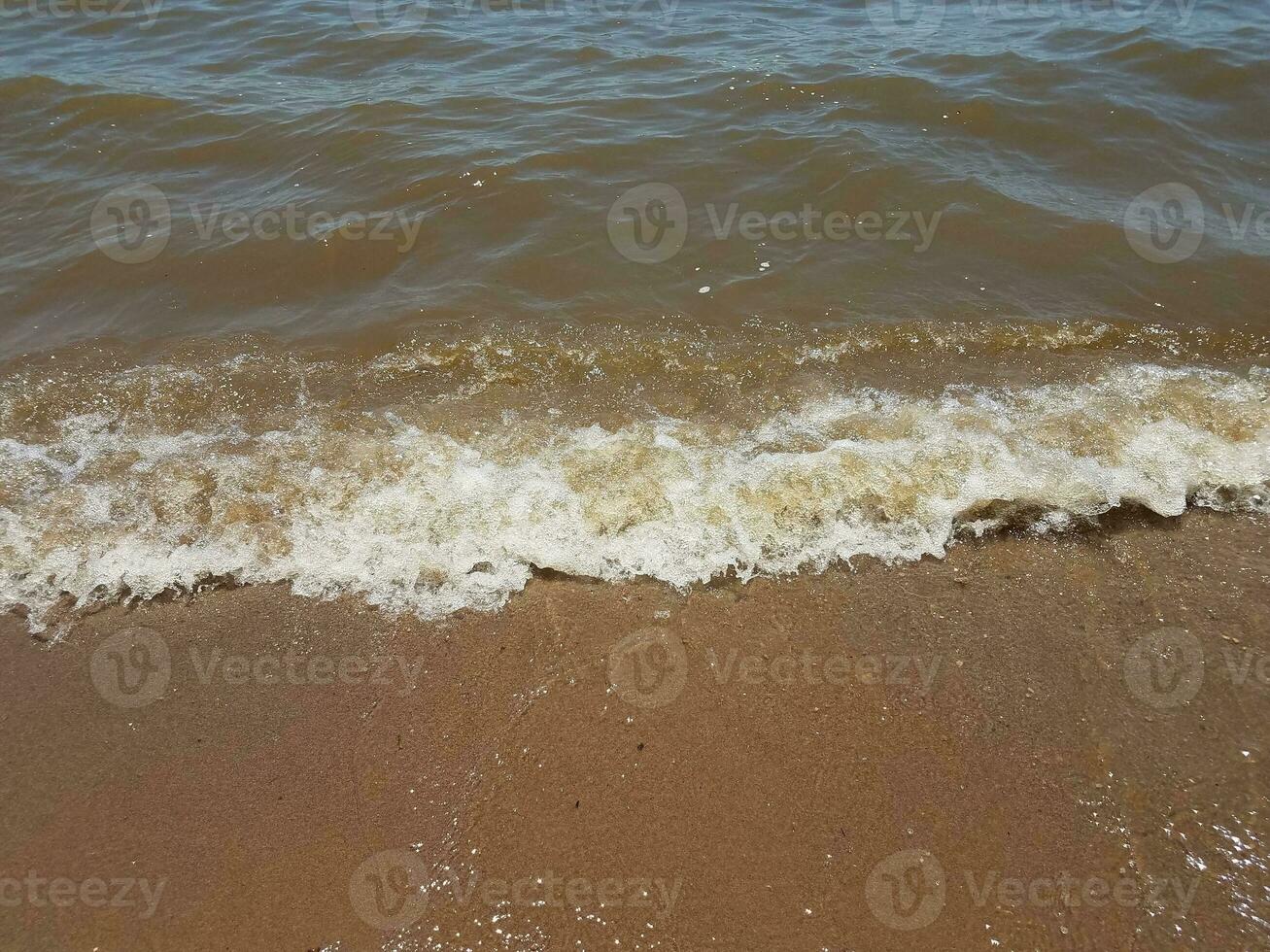 areia com ondas e pedras foto