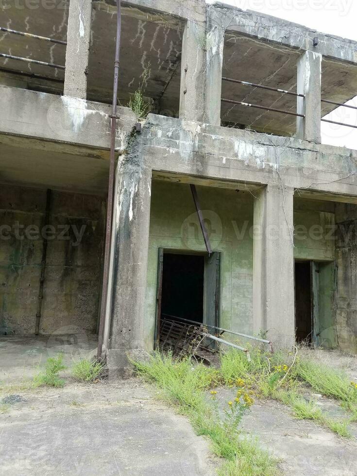 antigo prédio de cimento abandonado com ervas daninhas foto