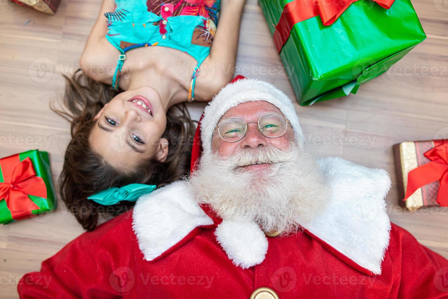 papai noel entregando uma caixa de presente para uma garotinha. véspera de natal, entrega de presentes. foto