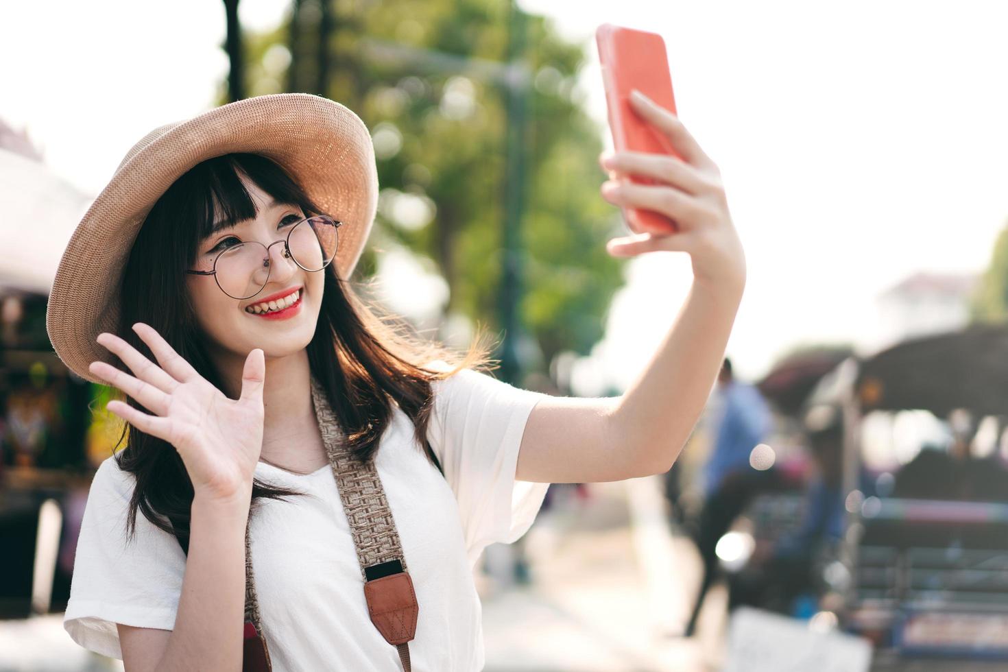 jovem garota de influência asiática viajando em bangkok com smartphone para upload na rede social. foto