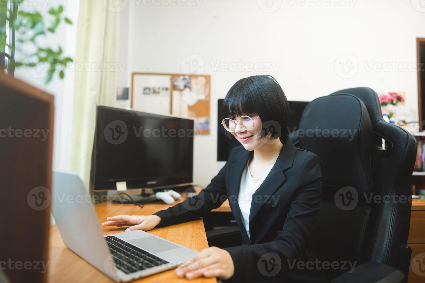 jovem mulher asiática adulta usando computador portátil para trabalho de videochamada em casa no dia. foto