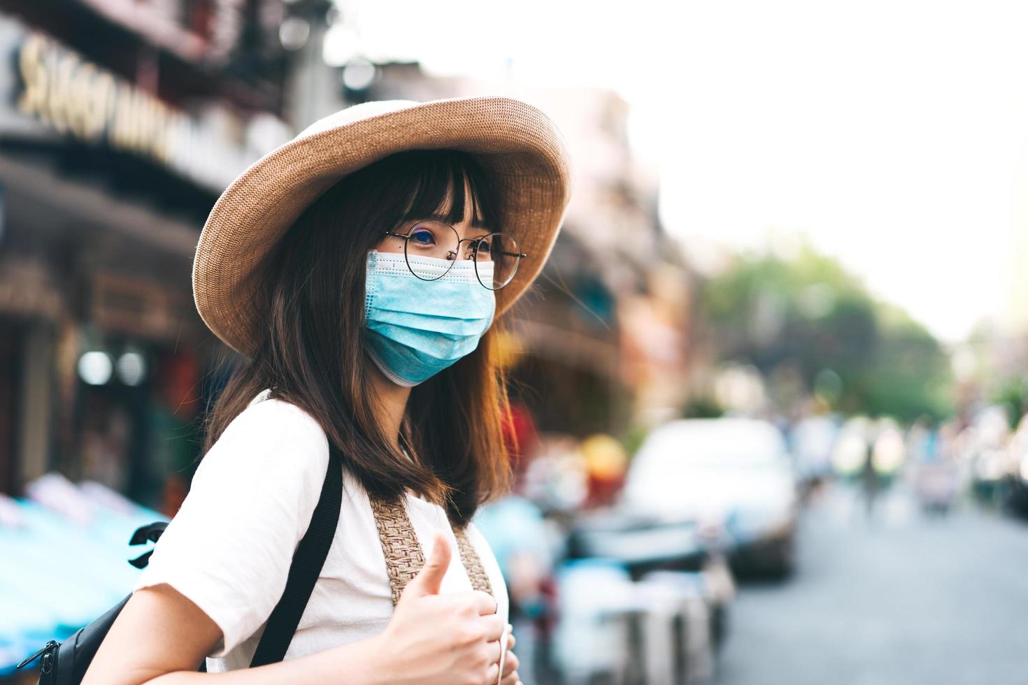 garota de óculos de jovem viajante asiático com chapéu e máscara protegem pm 2.5 e vírus. foto