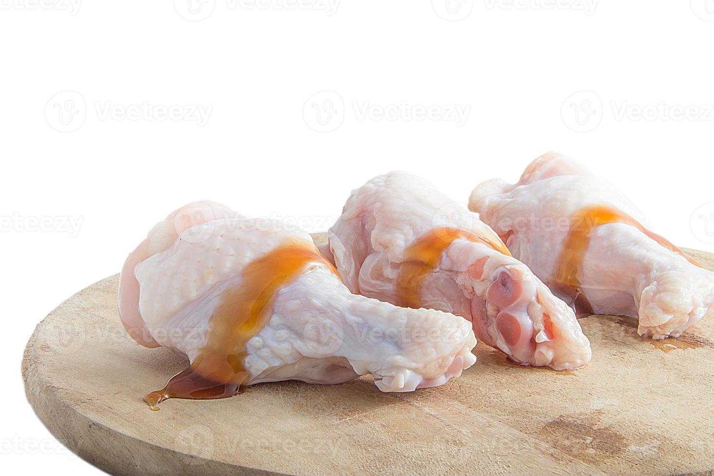 pernas de frango cru em tábuas de madeira no fundo branco foto