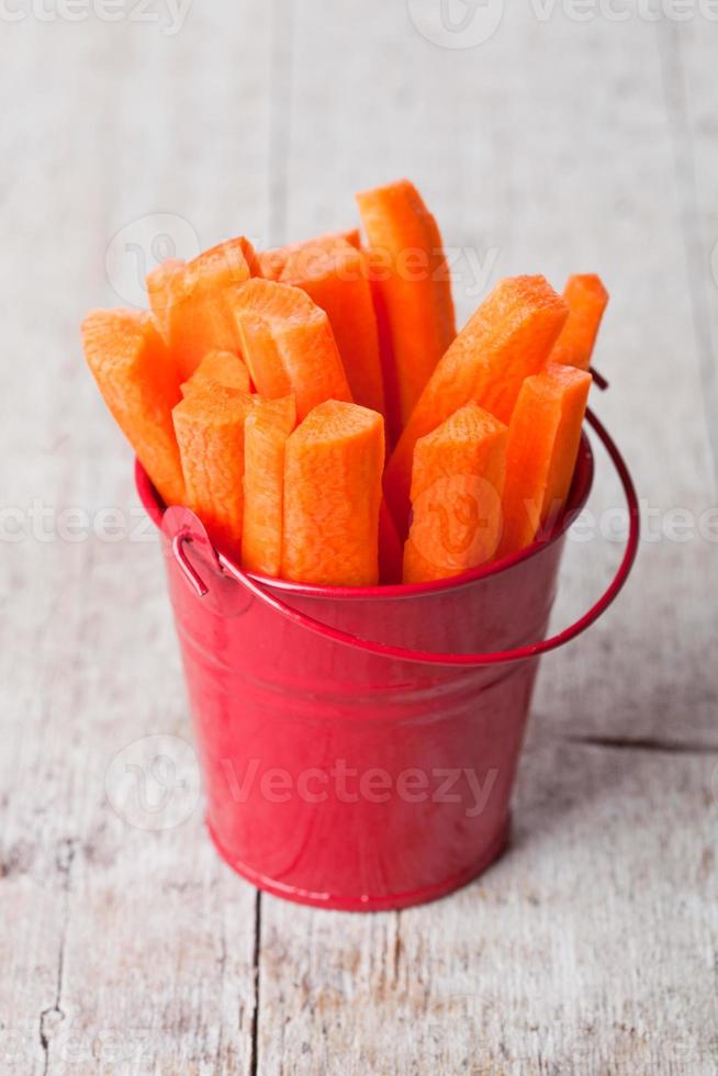cenoura em fatias fresca no balde vermelho foto