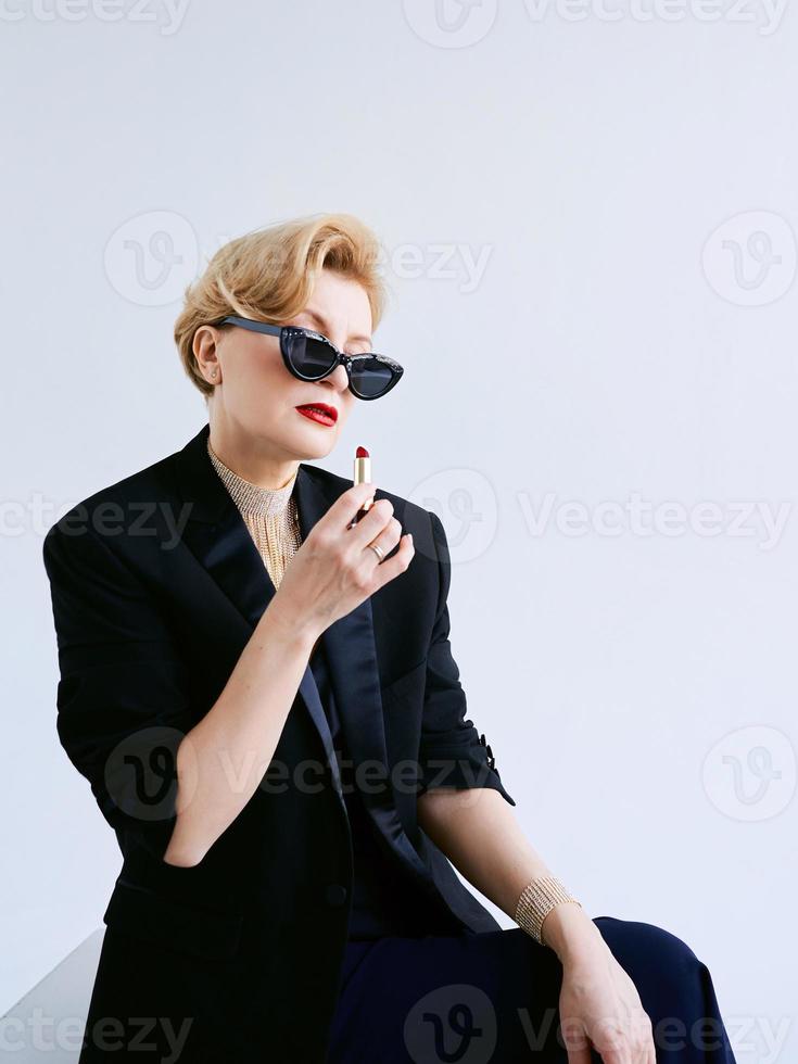 mulher madura elegante de smoking com batom. maquiagem, moda, conceito antienvelhecimento foto