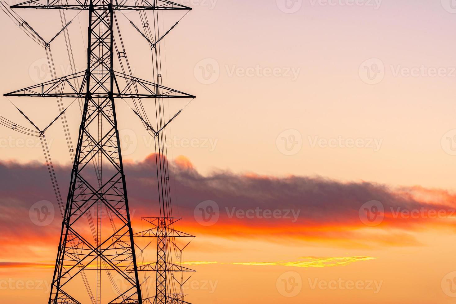 poste elétrico de alta tensão e linhas de transmissão à noite. postes de eletricidade ao pôr do sol. potência e energia. conservação de energia. torre de grade de alta tensão com cabo de arame na estação de distribuição. foto