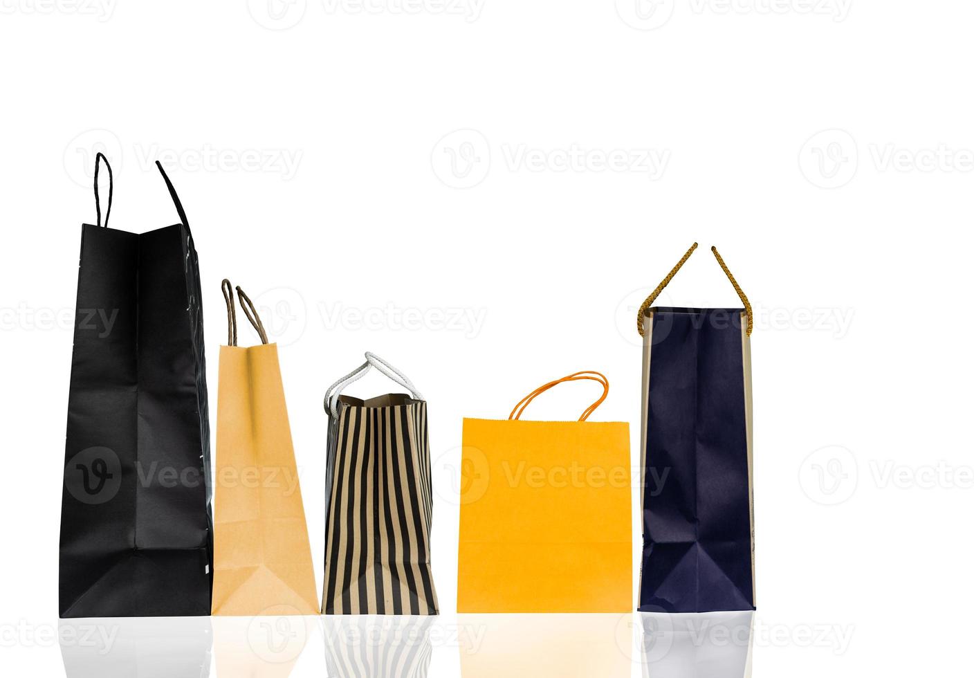 cinco sacolas de papel isoladas no fundo branco. saco de compras com cor azul, marrom e amarelo. conceito de vendas com desconto. embalagem de presente. conceito de consumismo. saco de presente de natal ou ano novo. foto