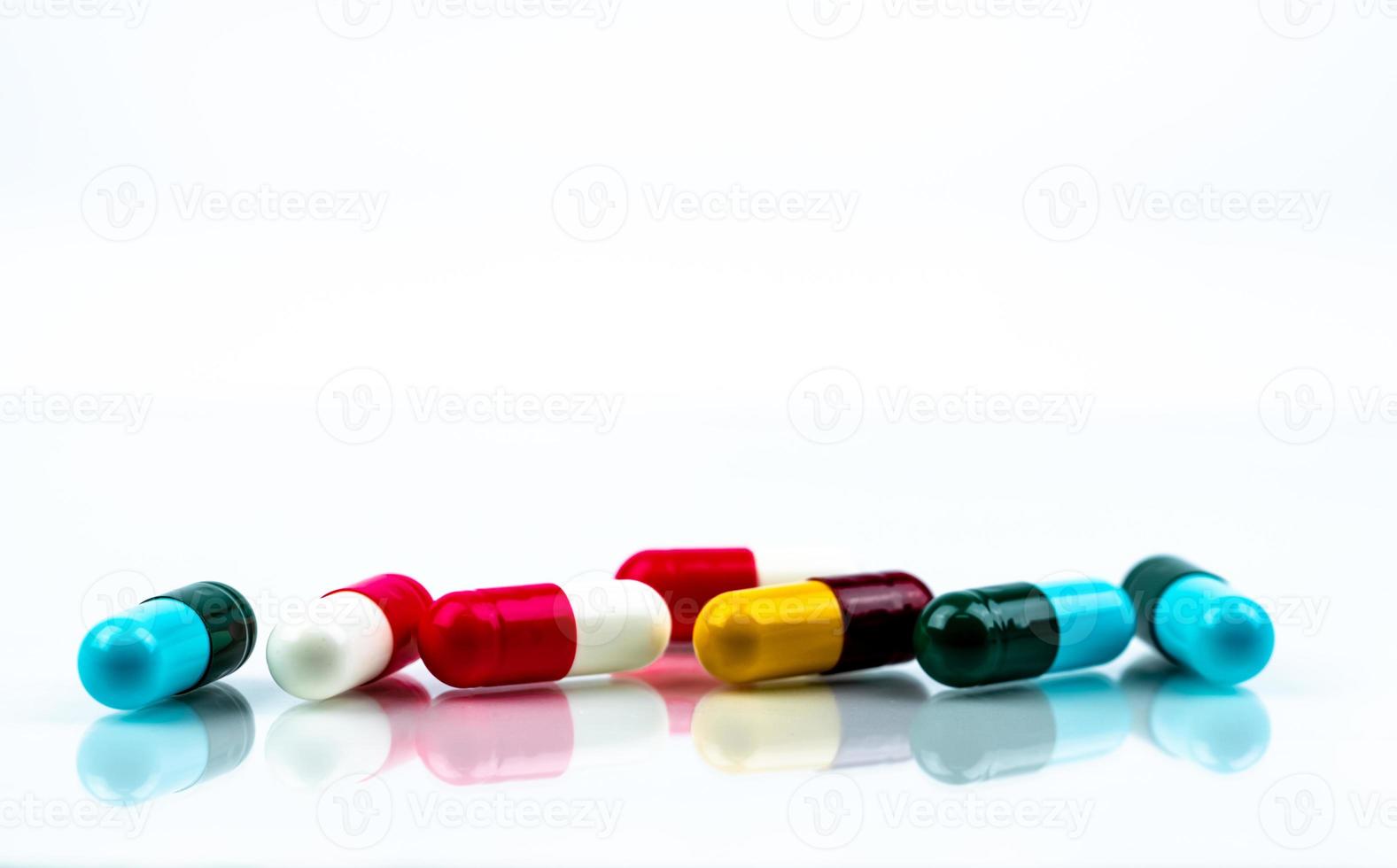 pílulas de cápsula de antibiótico colorido sobre fundo branco. conceito farmacêutico. resistência a antibióticos. indústria farmacêutica. farmácia drogaria. medicamento de saúde. cápsula antimicrobiana. foto