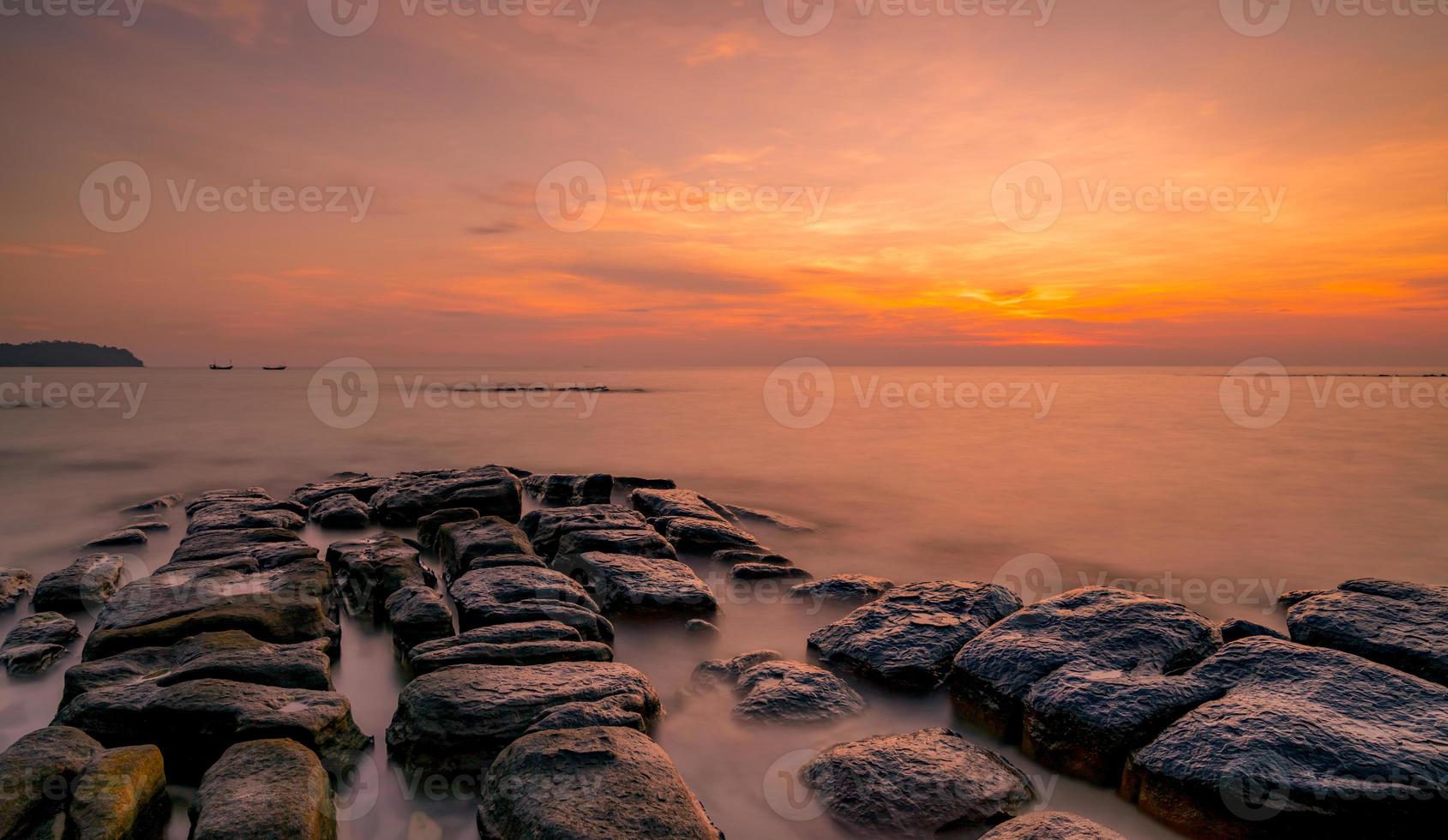 rochas na praia de pedra ao pôr do sol. lindo céu do sol da praia. mar e céu crepusculares. mar tropical ao entardecer. céu dramático e nuvens. abstrato por do sol. acalme e relaxe a vida. paisagem da natureza. foto