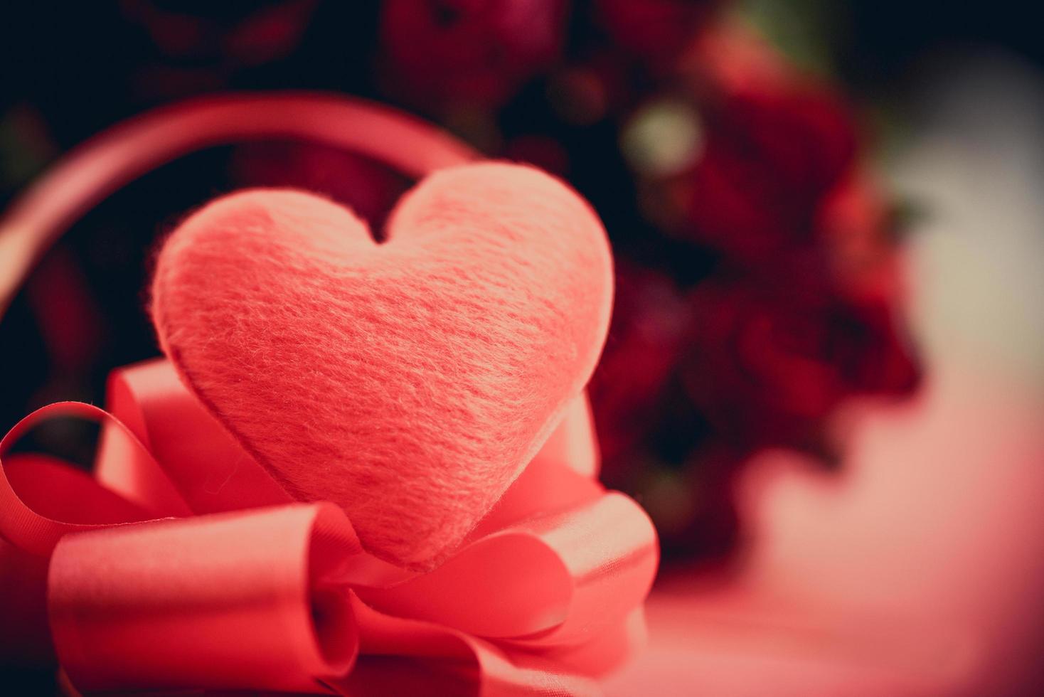 coração vermelho com buquê de rosas de flores em fundo vermelho - coração no laço de fita e conceito de dia dos namorados amor romântico rosa foto
