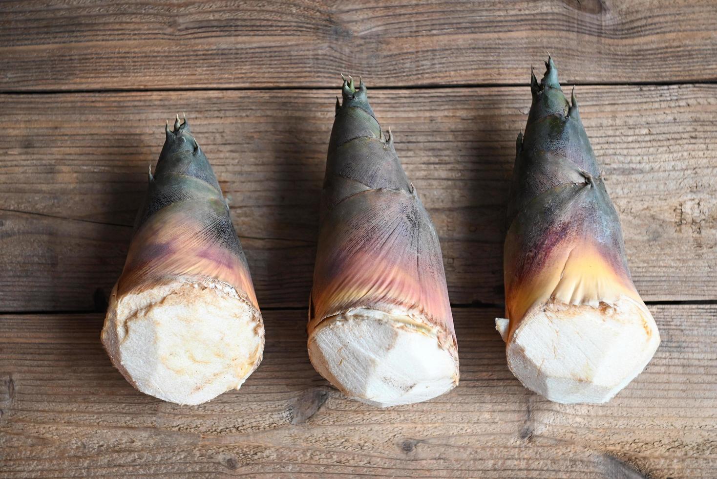 brotos de bambu no fundo da mesa de madeira, broto de bambu cru fresco para cozinhar alimentos na tailândia foto