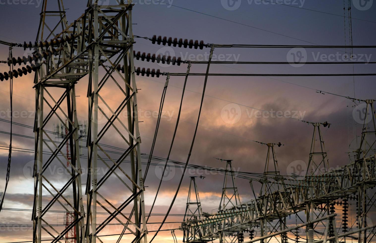 poste elétrico de alta tensão e fio elétrico contra céu tempestuoso e nuvens. torre de grade de alta tensão com cabo de arame. linhas de transmissão na torre da rede de alta tensão. energia elétrica trifásica. foto