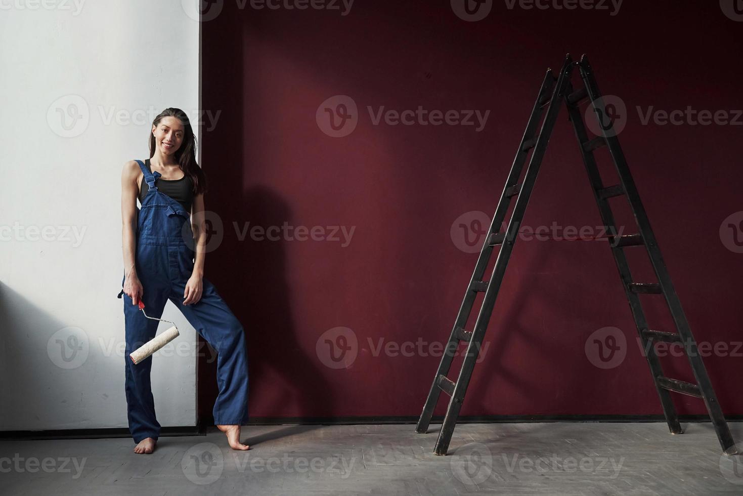 parece um trabalho bem feito. jovem dona de casa decidiu colar papel de parede em sua nova casa no quarto foto