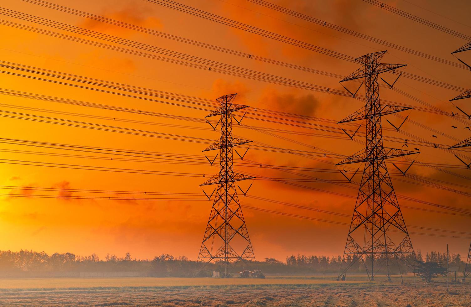 poste elétrico de alta tensão e fio elétrico com céu pôr do sol. postes de eletricidade. conceito de potência e energia. torre de grade de alta tensão com cabo de arame. lindo céu pôr do sol vermelho-alaranjado. a infraestrutura. foto