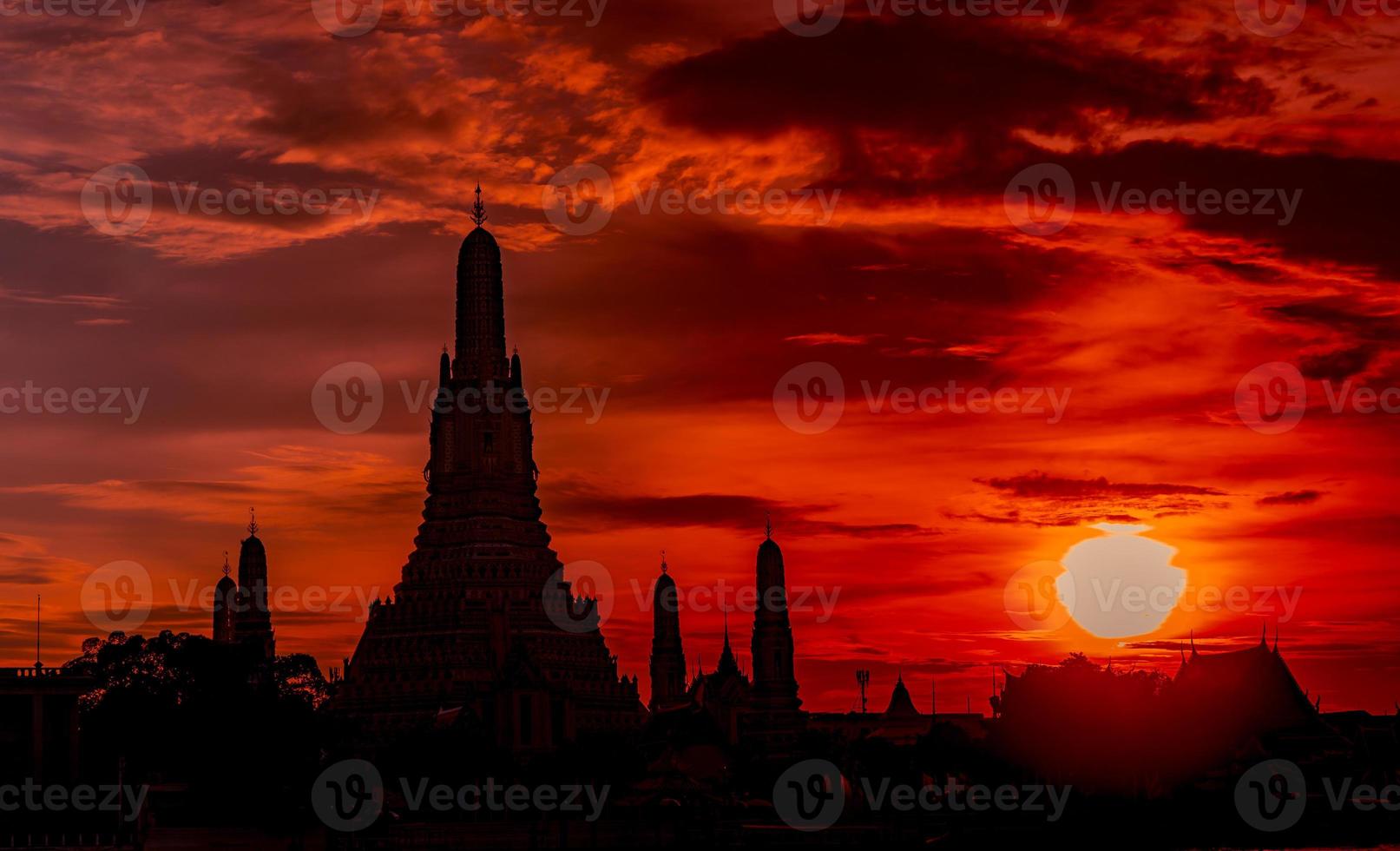 wat arun ratchawararam ao pôr do sol com lindo céu vermelho e laranja e nuvens. o templo budista wat arun é o marco em bangkok, tailândia. arte de atração. silhueta dramática céu e templo. foto