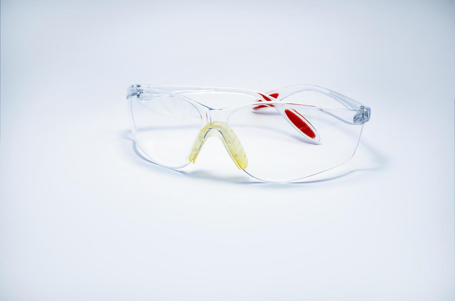 óculos de segurança plásticos isolados no fundo branco. óculos de proteção para os olhos do trabalhador no canteiro de obras ou na fábrica. ferramentas de segurança e proteção no local de trabalho. óculos de proteção uso em laboratório foto
