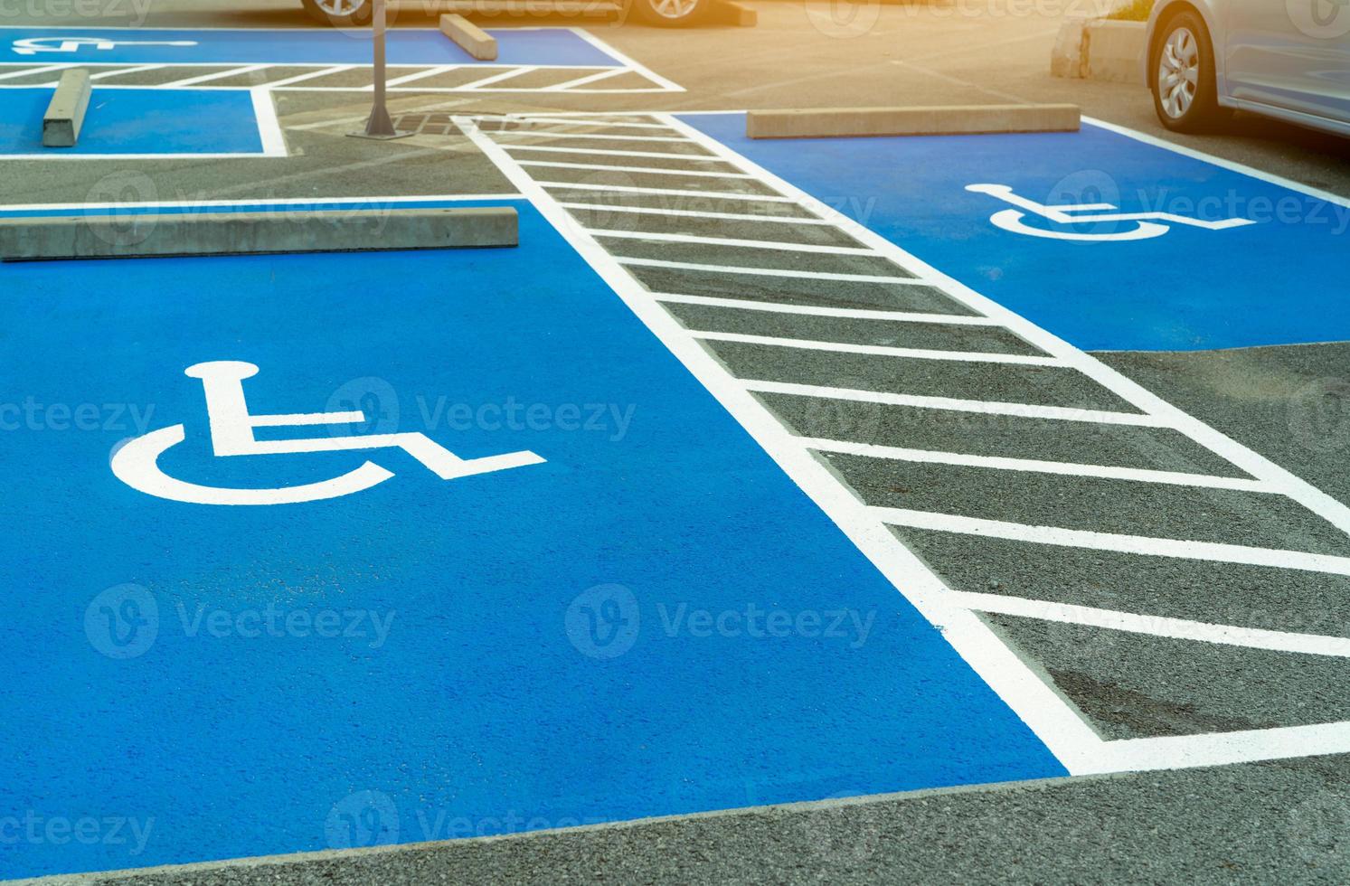 estacionamento de asfalto reservado para motorista deficiente em supermercado ou shopping center. vaga de estacionamento para deficientes físicos. pintura de sinal de cadeira de rodas na área de estacionamento de asfalto. estacionamento para deficientes. foto