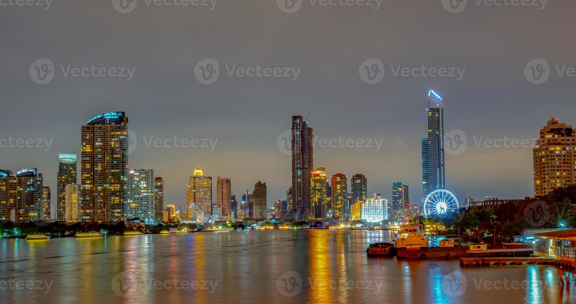 paisagem urbana do edifício moderno perto do rio no meio da noite. prédio de escritórios de arquitetura moderna. arranha-céu com céu noturno. imagem de tom preto e branco. fotografia noturna do edifício ribeirinho. foto