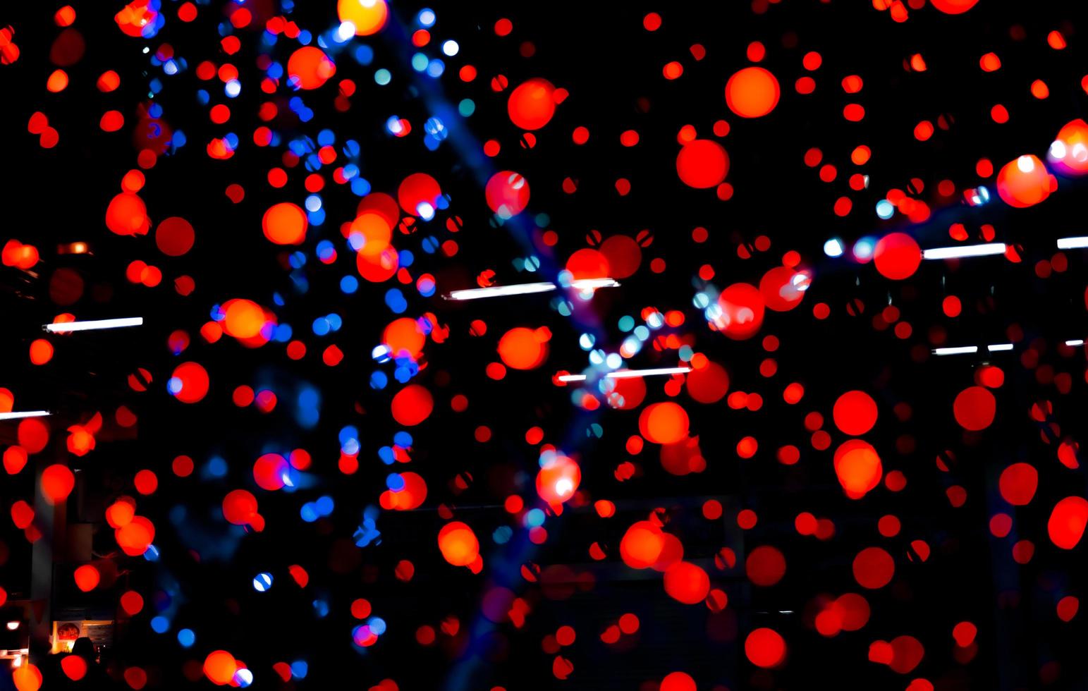 luz de decoração de natal e feliz ano novo. fundo de bokeh de cor vermelha, azul e laranja com belo padrão. luz de natal desfocada na noite da festa. fundo de bokeh de férias de natal. foto