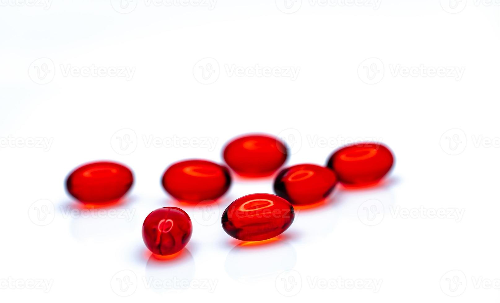 comprimidos de cápsula de gel macio vermelho isolados no fundo branco. pilha de cápsula de gelatina mole vermelha. conceito de vitaminas e suplementos dietéticos. indústria farmacêutica. farmácia drogaria. produtos de saúde. foto