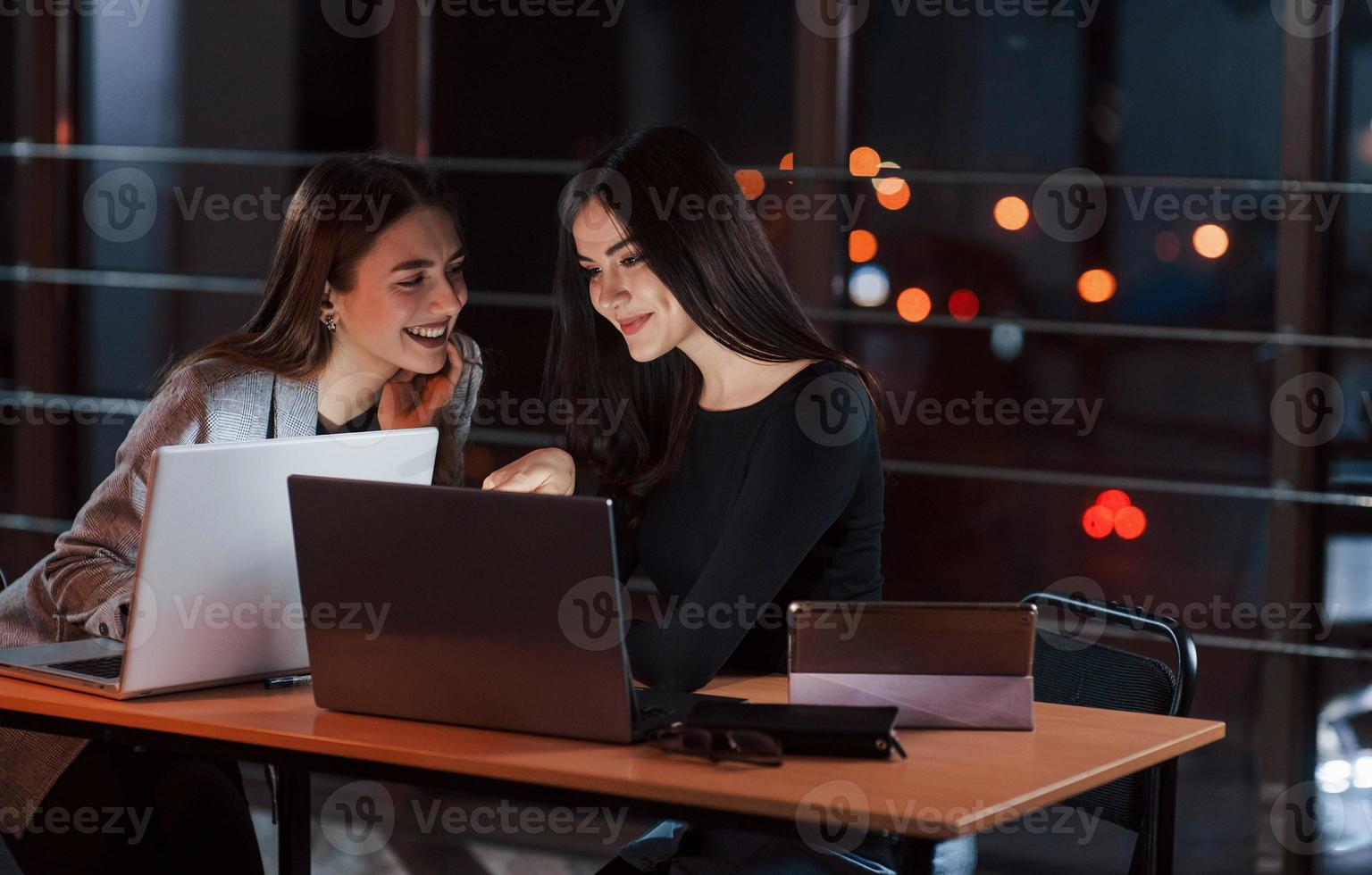 É realmente engraçado. equipe de jovens empresários trabalha em seu projeto à noite no escritório foto