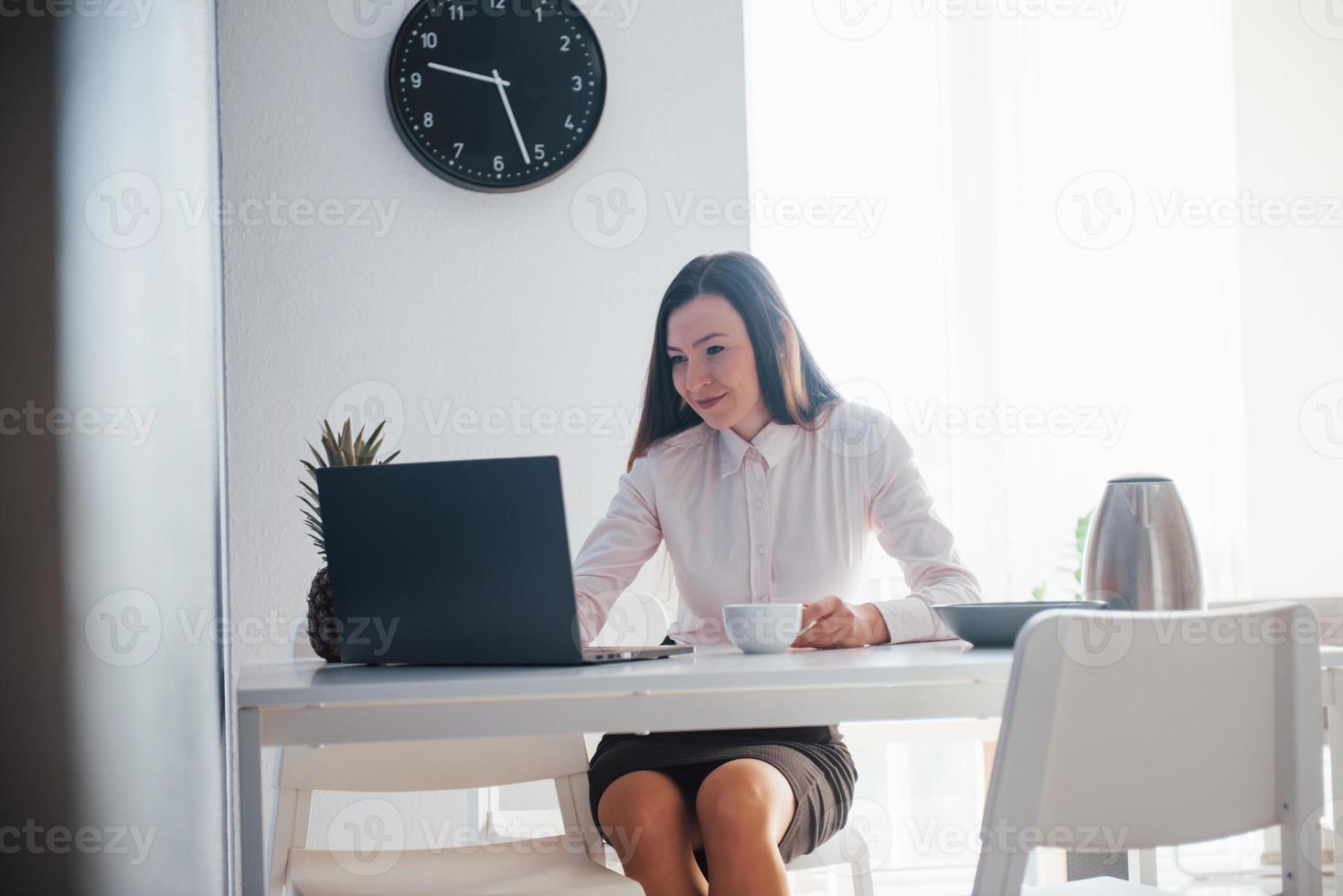 novo dia de trabalho. jovem empresária com cabelo preto em roupas oficiais em sua casa foto