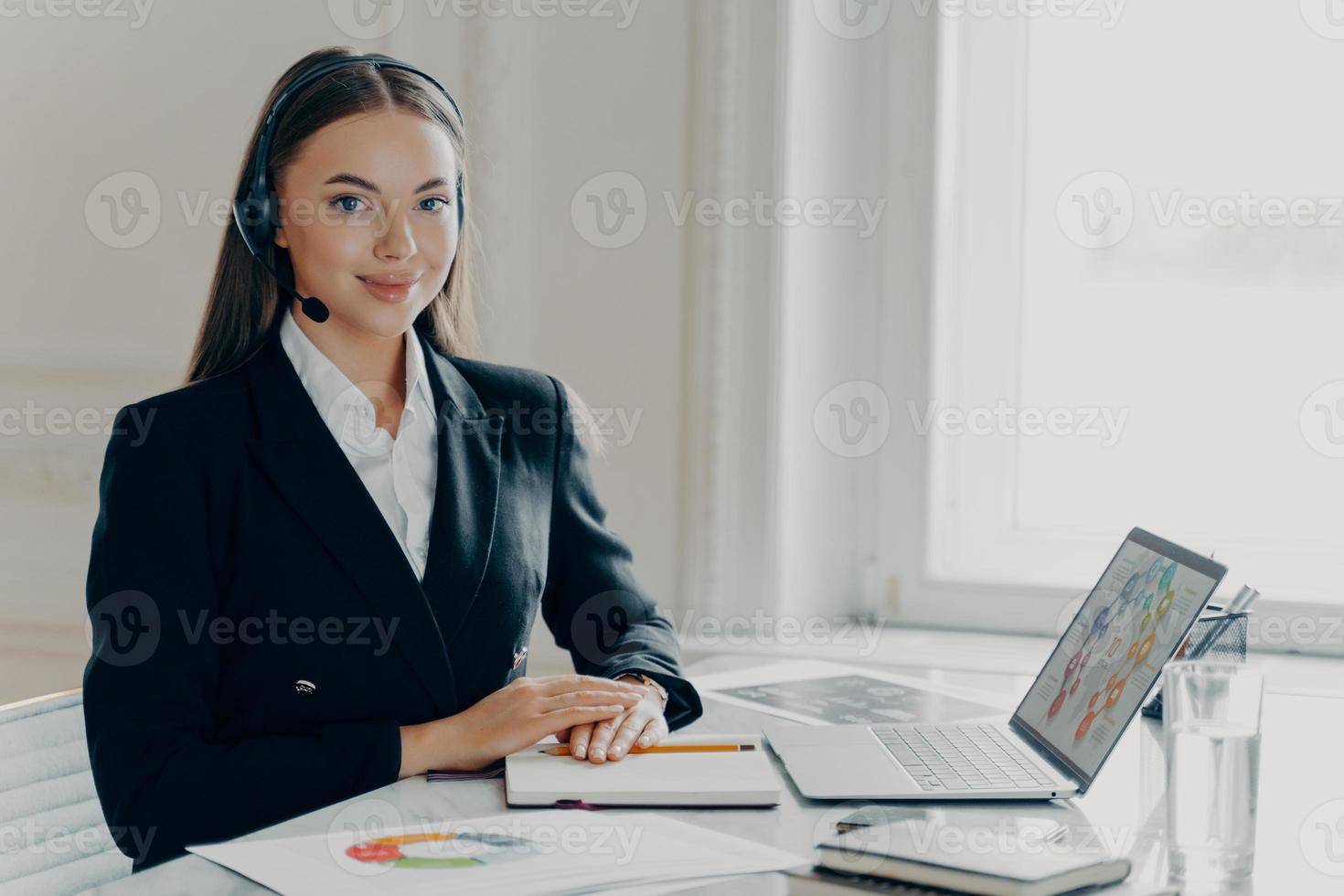 senhora de negócios feliz no fone de ouvido analisando gráficos gráficos foto