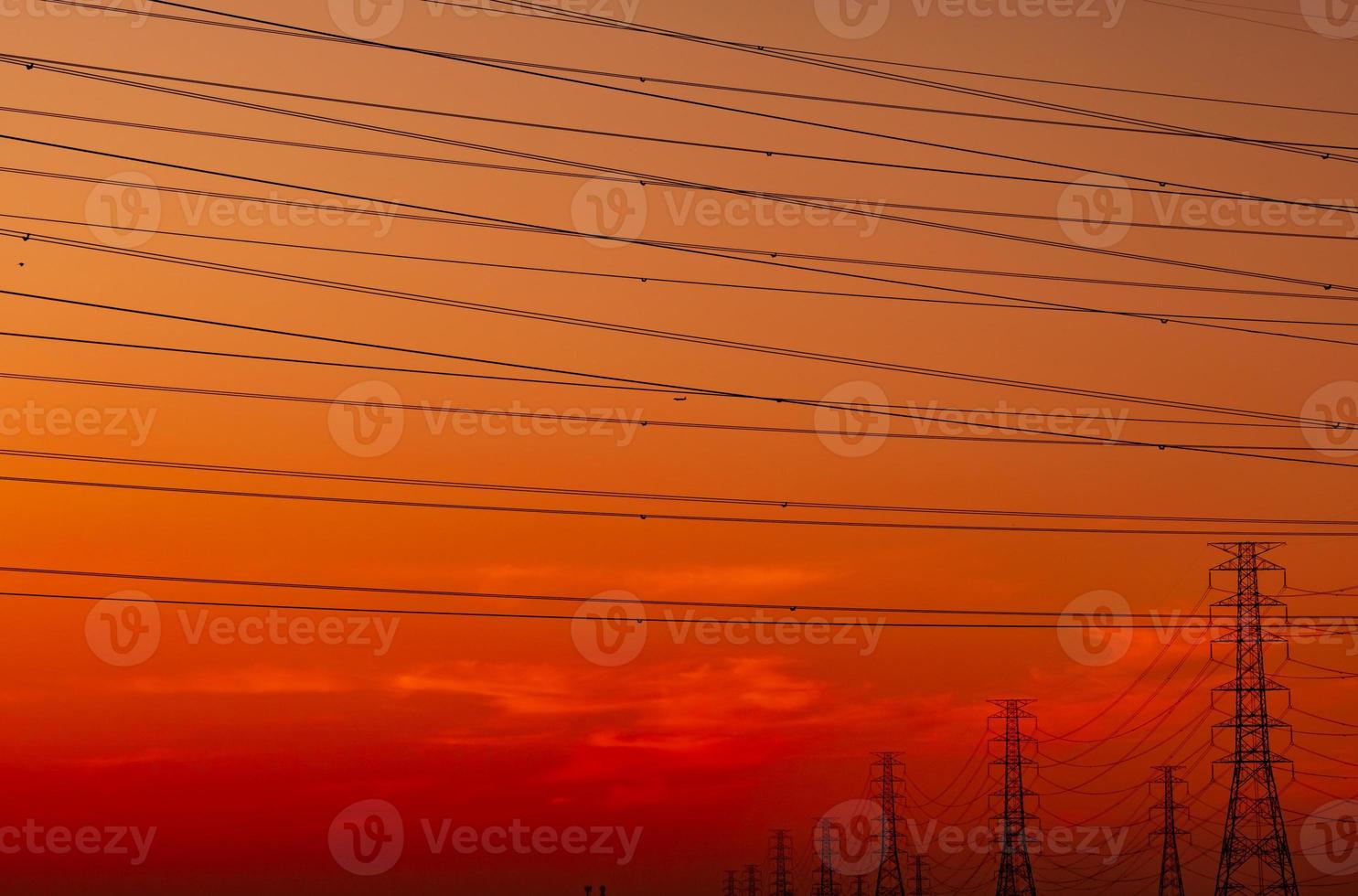 poste elétrico de alta tensão e fio elétrico com céu pôr do sol. postes de eletricidade. conceito de fábrica de suporte de energia e energia. torre de grade de alta tensão com cabo de arame. lindo céu pôr do sol vermelho-alaranjado. foto