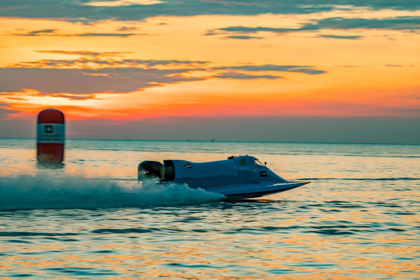 chonburi, tailândia-25 de novembro de 2017 barco f1 com lindo céu e mar com pôr do sol em bangsaen power boat 2017 na praia de bangsaen na tailândia foto