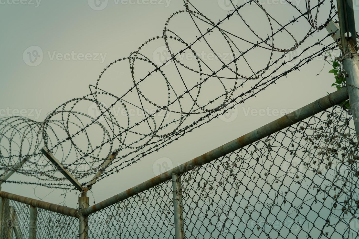 cerca de segurança da prisão. cerca de segurança de arame farpado. cerca de prisão de arame farpado. fronteira de barreira. muro de segurança do limite. prisão para prender criminosos ou terroristas. espaço privado. conceito de zona militar. foto