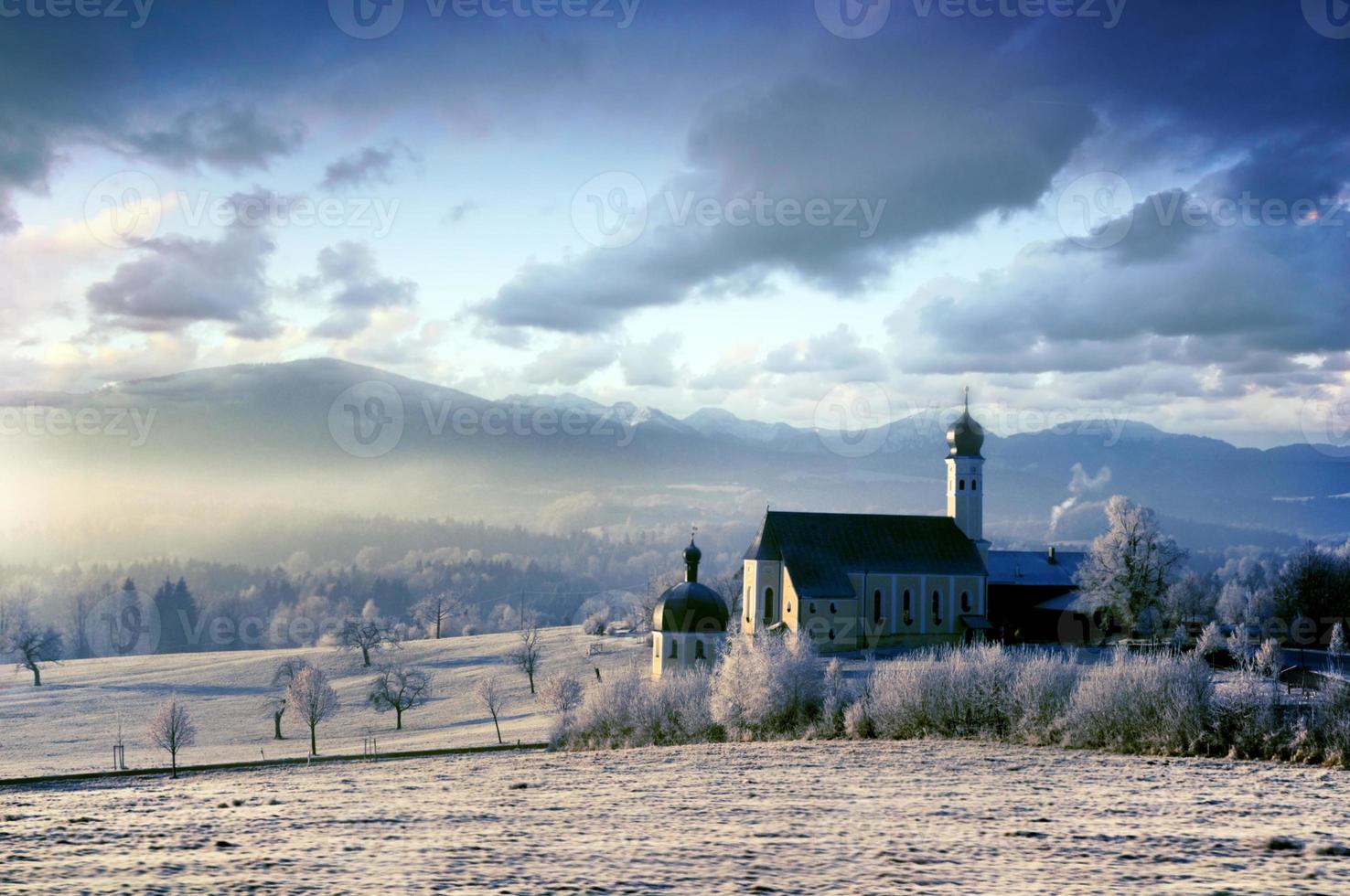 cenário alpino com igreja na manhã gelada foto