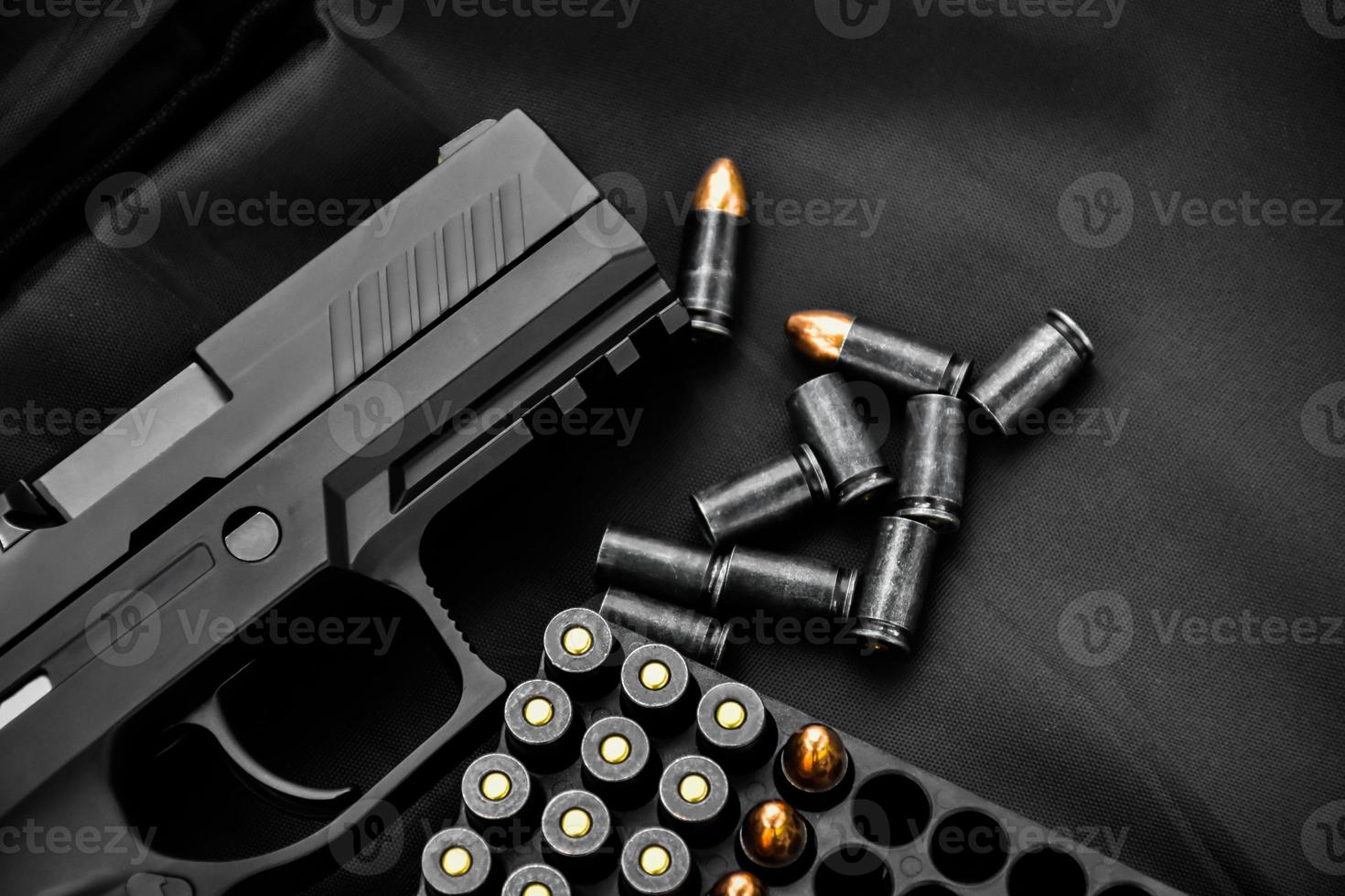 Pistola automática de 9 mm e balas no piso de madeira, foco suave e seletivo. foto