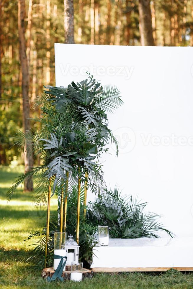 decorações de casamento em cerimônia de luxo. arco para cerimônia de casamento a é decorado com flores e verdes, hortaliças. decoração de casamento ao ar livre na floresta em dia ensolarado de verão. foto