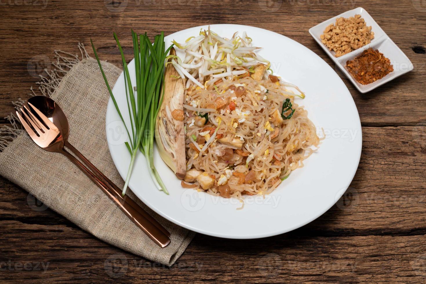 almofada de macarrão de arroz frito tailandês tem ovo vegetal na mesa de madeira. foto