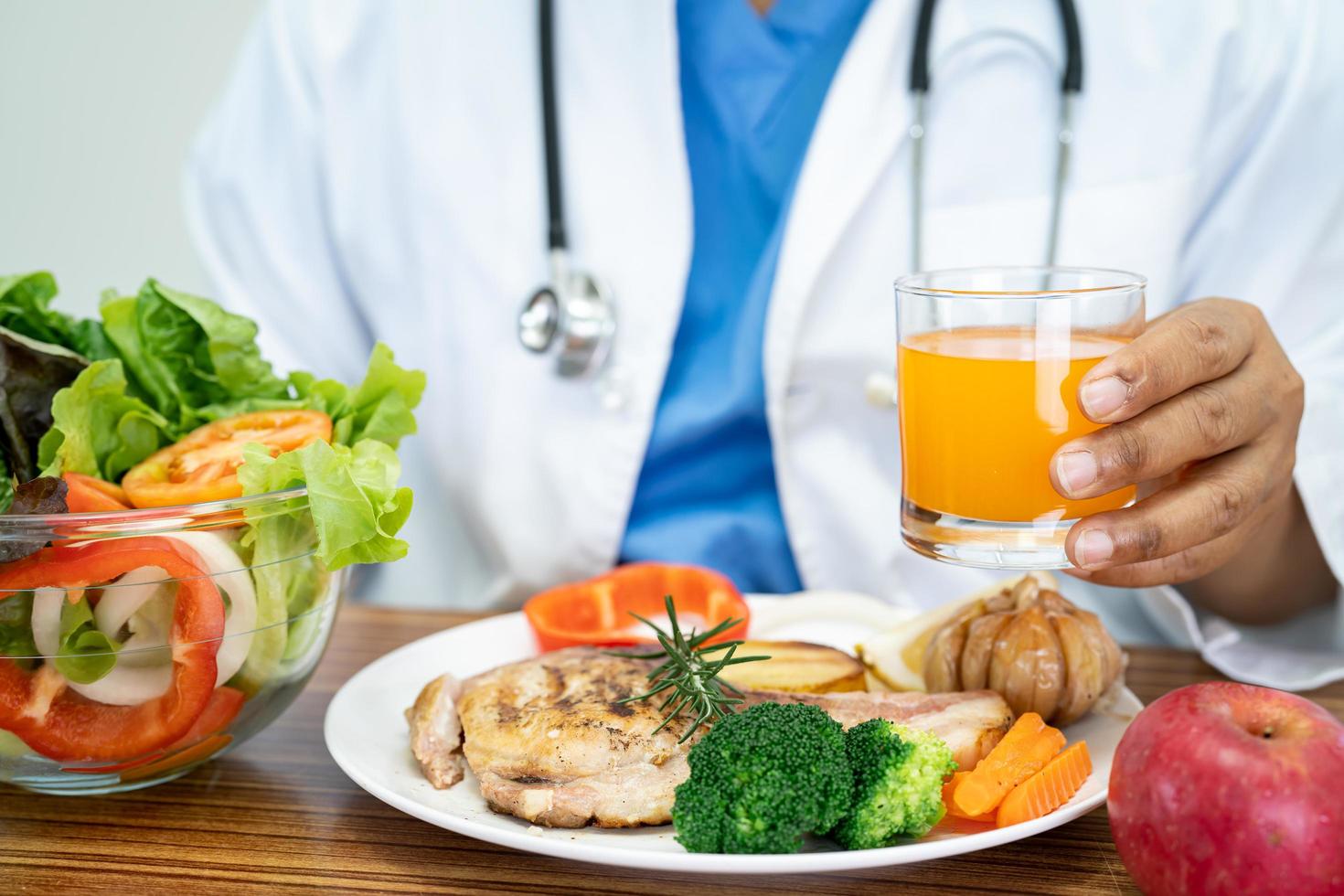 médico nutricionista com vários legumes frescos saudáveis para o paciente. foto