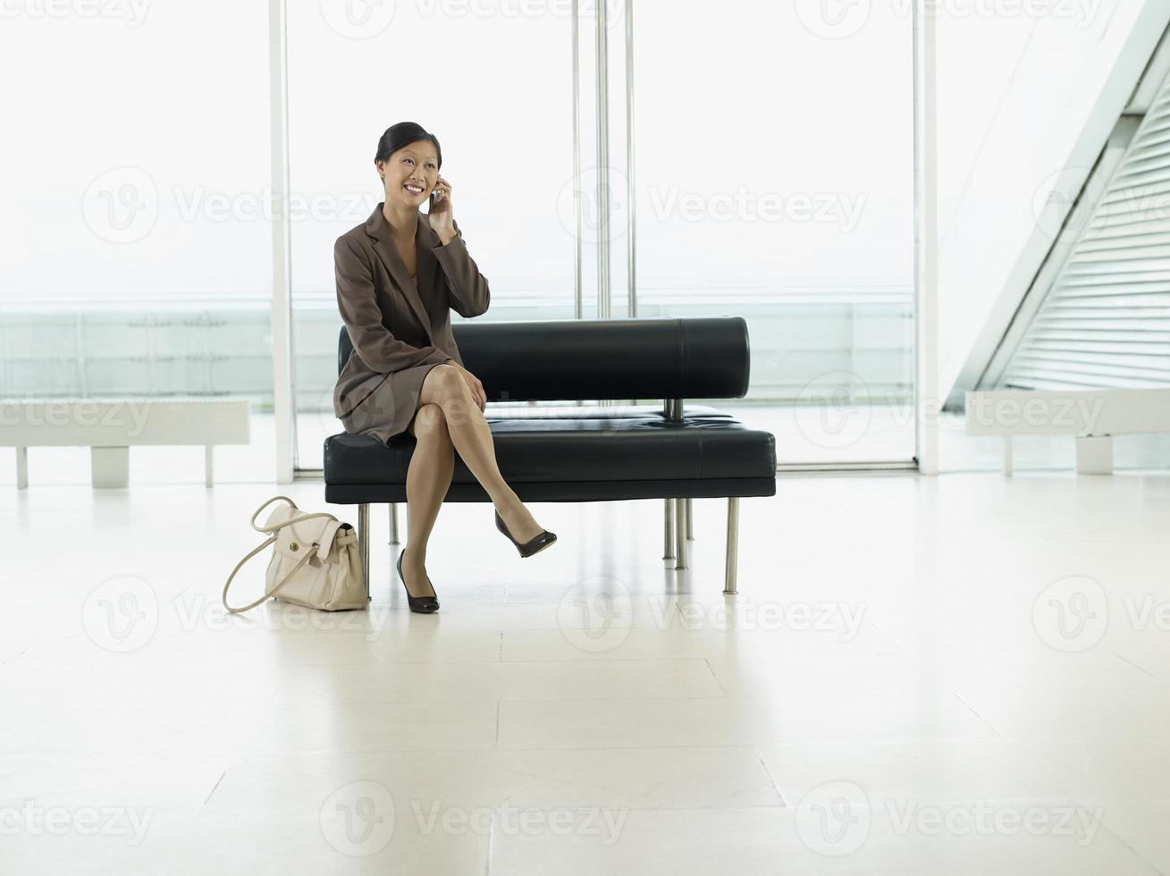 empresária usando celular no saguão do aeroporto foto