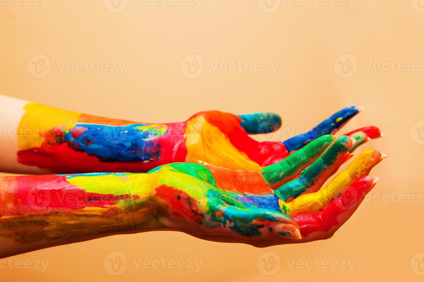 mãos pintadas, diversão colorida. fundo laranja foto