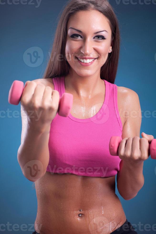 mulher bonita fitness fazendo exercícios com pesos foto