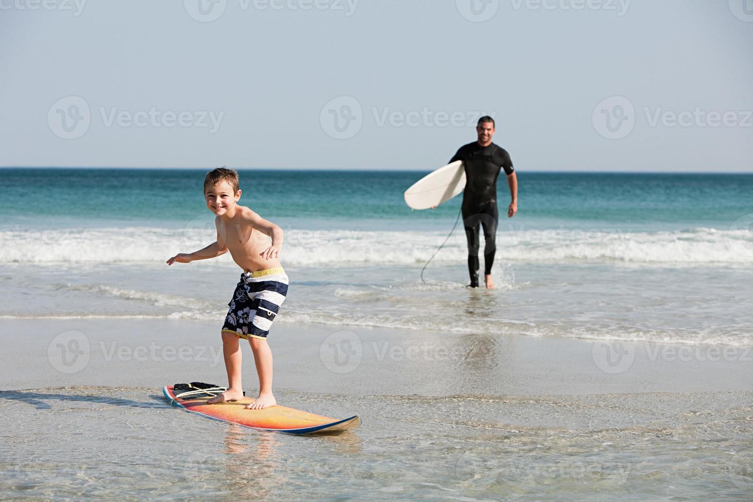 menino surfando em águas rasas foto