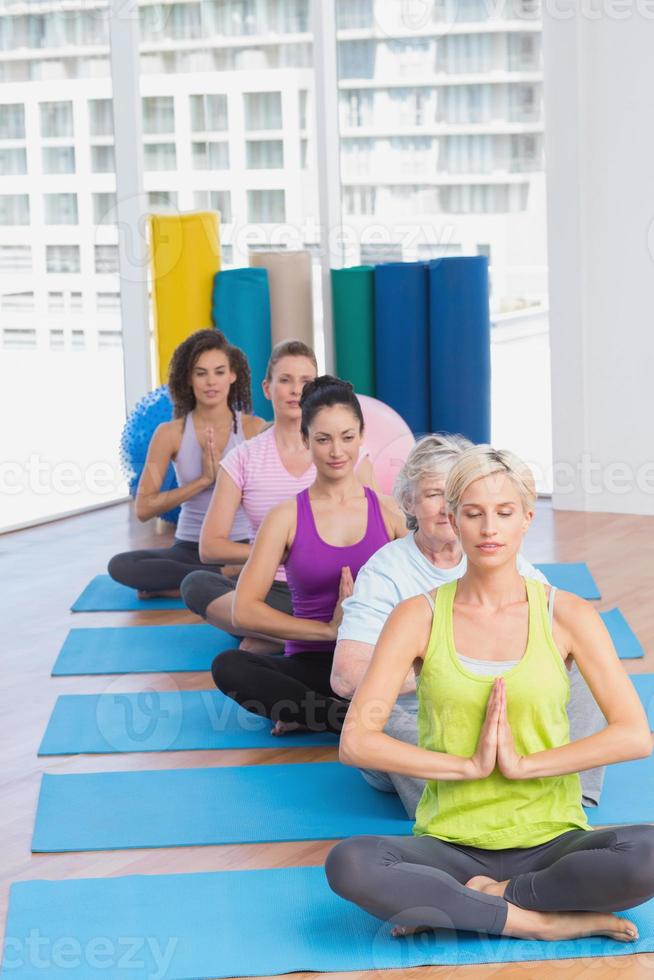 mulheres meditando na aula de fitness foto