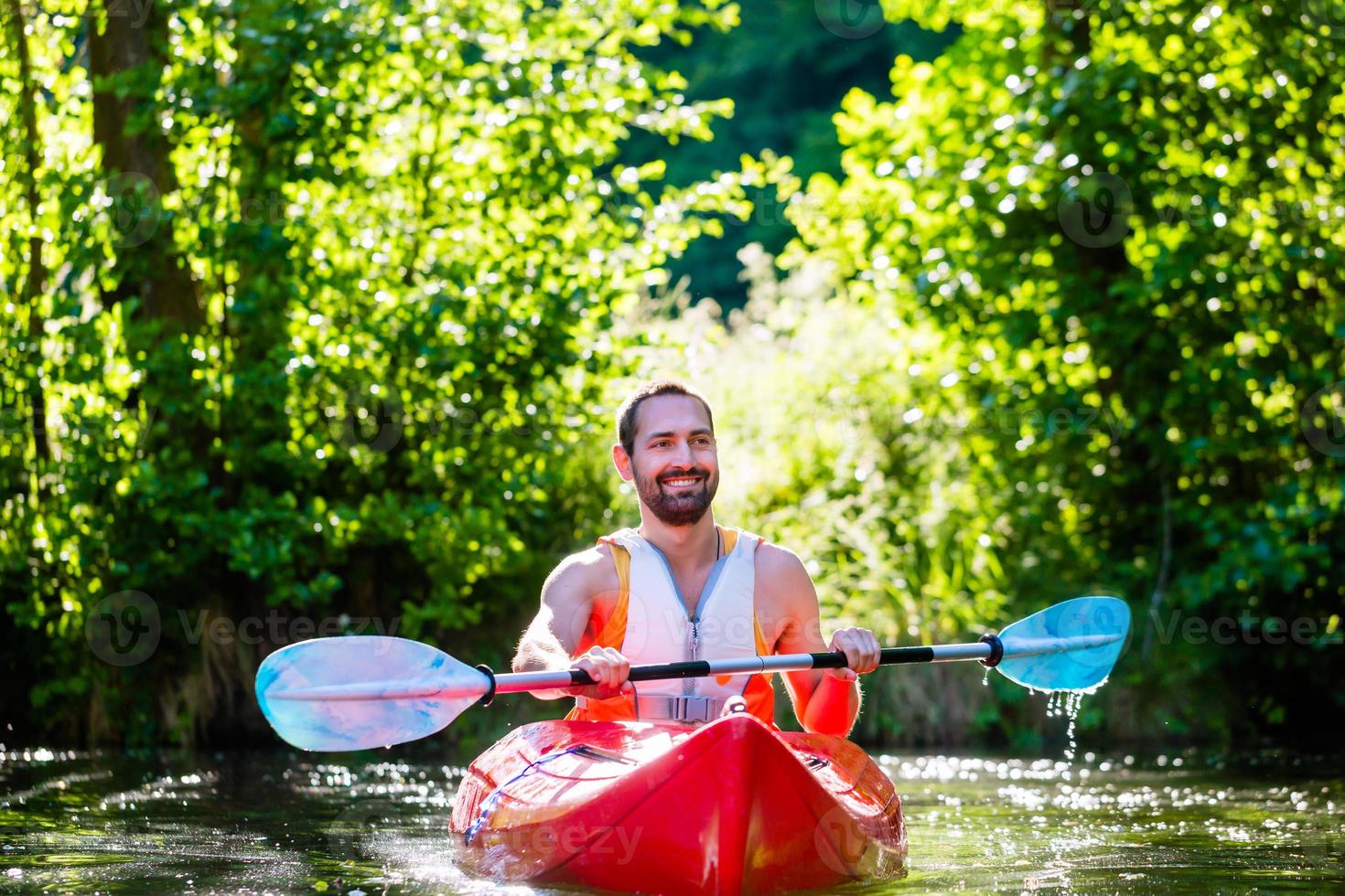 homem remando com caiaque no rio para o esporte aquático foto