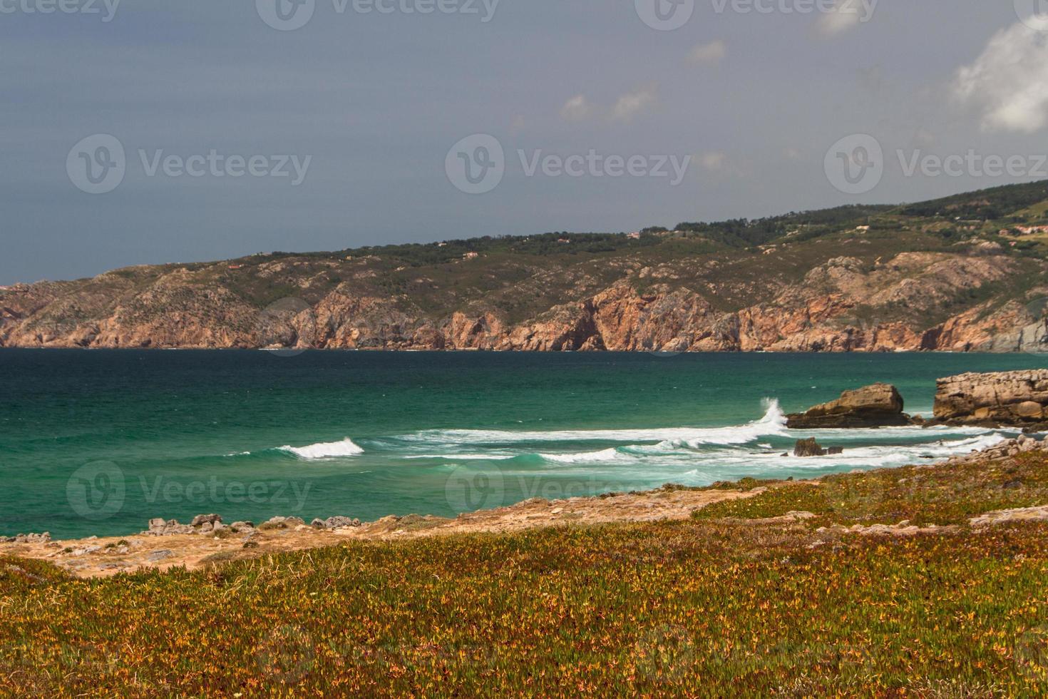 as ondas lutando sobre a costa rochosa deserta do oceano atlântico, portugal foto