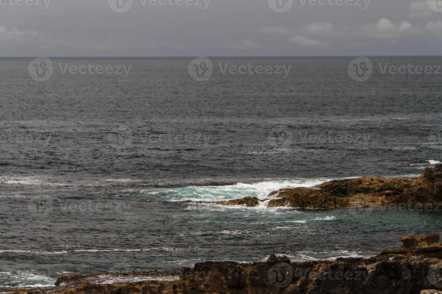 as ondas lutando sobre a costa rochosa deserta do oceano atlântico, portugal foto